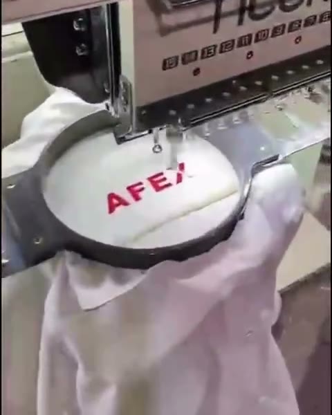 Letras rojas bordadas sobre una prenda blanca